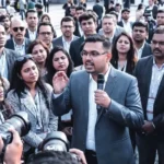 AI के दौर में बदल रही नौकरियों की दुनिया: भारत के टेक वर्कफोर्स में बढ़ता स्किल गैप और “Smart Shift” की जरूरत भारत का टेक सेक्टर एक बड़े बदलाव के दौर से गुजर रहा है। जहां एक ओर आर्टिफिशियल इंटेलिजेंस (AI) और ऑटोमेशन नई संभावनाएं खोल रहे हैं, वहीं दूसरी ओर यह बदलाव लाखों प्रोफेशनल्स के लिए चुनौती भी बनता जा रहा है। पारंपरिक डिग्री और पुराने स्किल सेट अब उतने प्रभावी नहीं रहे, जितने कुछ साल पहले हुआ करते थे। इसी बदलते परिदृश्य के बीच पश्चिम बंगाल के एक युवा टेक प्रोफेशनल Joydeep Dutta की कहानी सामने आई है, जो भारत के आईटी वर्कफोर्स में तेजी से बढ़ रहे “स्किल गैप” को उजागर करती है। उनका अनुभव सिर्फ व्यक्तिगत संघर्ष नहीं, बल्कि एक बड़े सिस्टमेटिक बदलाव का संकेत है। 50 रिजेक्शन के बाद समझ आया असली फर्क: डिग्री बनाम स्किल Joydeep Dutta, जो कि एक MCA ग्रेजुएट हैं और पश्चिम बंगाल के ग्रामीण क्षेत्र से आते हैं, ने अपने करियर की शुरुआत में करीब 50 जॉब रिजेक्शन का सामना किया। यह स्थिति इसलिए और गंभीर हो जाती है क्योंकि उनके पास पोस्टग्रेजुएट डिग्री थी, जो पारंपरिक रूप से आईटी सेक्टर में एक मजबूत योग्यता मानी जाती है। लेकिन यहां एक बड़ा सवाल खड़ा होता है— अगर डिग्री होने के बावजूद नौकरी नहीं मिल रही, तो समस्या कहां है? डुट्टा के अनुसार, समस्या “क्वालिफिकेशन” में नहीं, बल्कि इंडस्ट्री की बदलती जरूरतों और शिक्षा के बीच बढ़ते अंतर में है। आज की टेक इंडस्ट्री तेजी से AI-ड्रिवन हो रही है, जहां सिर्फ कोडिंग या थ्योरी नहीं, बल्कि प्रैक्टिकल AI स्किल्स की मांग है। AI ने बदली डेवलपमेंट की परिभाषा पहले जहां सॉफ्टवेयर डेवलपर्स खुद कोड लिखते थे, अब स्थिति बदल रही है। Joydeep Dutta ने जयपुर में एक प्रेस इंटरैक्शन के दौरान बताया कि आज के समय में सीनियर डेवलपर्स का रोल “कोड लिखने” से ज्यादा “AI मॉडल्स को डायरेक्ट करने” का हो गया है। इसका मतलब है: डेवलपर अब AI टूल्स को गाइड करते हैं ऑटोमेशन से काम की गति बढ़ी है कम समय में ज्यादा प्रोडक्टिविटी संभव है यह बदलाव उन लोगों के लिए खतरे की घंटी है, जो अभी भी पुराने तरीकों पर निर्भर हैं। सबसे ज्यादा खतरे में कौन-सी जॉब्स? AI और ऑटोमेशन का असर सबसे ज्यादा कुछ खास क्षेत्रों पर पड़ रहा है। इंडस्ट्री अनुमान के अनुसार 2026 तक: करीब 80% रिग्रेशन टेस्टिंग ऑटोमेट हो जाएगी रूटीन डेटा मैनेजमेंट का बड़ा हिस्सा मशीनें संभालेंगी मैनुअल टेस्टिंग और लेगेसी आईटी रोल्स में भारी गिरावट आ सकती है इसका सीधा असर उन प्रोफेशनल्स पर पड़ेगा, जो: सिर्फ बेसिक स्किल्स पर निर्भर हैं नए टूल्स और टेक्नोलॉजी नहीं सीख रहे अपस्किलिंग को प्राथमिकता नहीं दे रहे “Smart Shift”: बदलाव का नया फॉर्मूला इन चुनौतियों के बीच Joydeep Dutta ने एक नया कॉन्सेप्ट पेश किया है—“Smart Shift”। यह कोई थ्योरी नहीं, बल्कि एक प्रैक्टिकल वर्कबुक फ्रेमवर्क है, जो बताता है कि कैसे एक व्यक्ति AI के साथ काम करना सीख सकता है। इस फ्रेमवर्क की खास बातें: AI को समझने और इस्तेमाल करने पर फोकस रोजमर्रा के काम में AI का इंटीग्रेशन कम संसाधनों में ज्यादा प्रोडक्टिविटी डुट्टा का मानना है कि आज एक लैपटॉप और AI की समझ पारंपरिक बड़े इंफ्रास्ट्रक्चर की जगह ले सकती है। “डिग्री नहीं, एडेप्टिव इंटेलिजेंस है नई करेंसी” Joydeep Dutta का सबसे बड़ा संदेश यह है कि आज के दौर में नौकरी पाने और टिके रहने के लिए सबसे जरूरी है Adaptive Intelligence। इसका मतलब है: नई टेक्नोलॉजी को जल्दी सीखने की क्षमता बदलते माहौल के अनुसार खुद को ढालना AI सिस्टम्स को कंट्रोल और ऑडिट करना उनका कहना है कि अब स्टैटिक डिग्री की वैल्यू कम हो रही है, जबकि AI स्किल्स की मांग तेजी से बढ़ रही है। भारत के टेक सेक्टर के लिए क्या है संकेत? यह कहानी सिर्फ एक व्यक्ति की नहीं, बल्कि पूरे भारतीय आईटी सेक्टर की स्थिति को दर्शाती है। भारत दुनिया का एक बड़ा टेक हब है, लेकिन अगर स्किल गैप बढ़ता गया, तो यह स्थिति चुनौती बन सकती है। मुख्य संकेत: शिक्षा प्रणाली को अपडेट करने की जरूरत इंडस्ट्री-ओरिएंटेड ट्रेनिंग पर जोर AI और ऑटोमेशन को कोर स्किल बनाना अगर यह बदलाव समय पर नहीं किया गया, तो लाखों युवाओं के लिए रोजगार के अवसर सीमित हो सकते हैं। जयपुर जैसे उभरते टेक हब की भूमिका Jaipur जैसे शहर अब नए टेक हब के रूप में उभर रहे हैं। यहां स्टार्टअप्स, डिजिटल प्रोफेशनल्स और फ्रीलांसर तेजी से बढ़ रहे हैं। ऐसे शहर “Smart Shift” जैसे कॉन्सेप्ट को अपनाने के लिए आदर्श हैं, क्योंकि यहां: नए प्रयोग करने की स्वतंत्रता है टेक कम्युनिटी तेजी से बढ़ रही है डिजिटल इकोनॉमी का विस्तार हो रहा है क्या करना होगा युवाओं को? अगर कोई युवा आज आईटी सेक्टर में करियर बनाना चाहता है, तो उसे कुछ जरूरी बदलाव करने होंगे: AI टूल्स सीखना डेटा एनालिटिक्स और ऑटोमेशन समझना लगातार अपस्किलिंग करना सिर्फ डिग्री पर निर्भर न रहना यह बदलाव आसान नहीं है, लेकिन भविष्य के लिए जरूरी है। निष्कर्ष: “Smart Shift” अब विकल्प नहीं, जरूरत है Joydeep Dutta की कहानी यह साफ करती है कि AI का दौर सिर्फ अवसर नहीं, बल्कि एक परीक्षा भी है। जो लोग समय के साथ खुद को बदलेंगे, वे आगे बढ़ेंगे। जो नहीं बदलेंगे, वे पीछे छूट सकते हैं। भारत के लिए यह एक महत्वपूर्ण समय है, जहां उसे अपने टेक वर्कफोर्स को AI-रेडी बनाना होगा। “Smart Shift” अब कोई अतिरिक्त स्किल नहीं, बल्कि करियर सर्वाइवल का आधार बन चुका है।