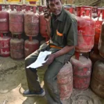 Man sitting among gas cylinders.