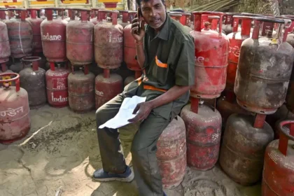 Man sitting among gas cylinders.