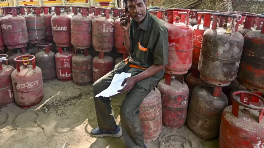 Man sitting among gas cylinders.