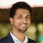 Success Story: 'क्या पिता की तरह मजदूरी करोगे?' टीचर के एक सवाल ने बदल दी किस्मत, 6वीं में फेल छात्र आज ₹4,000 करोड़ की कंपनी का मालिक Success Story of PC Musthafa: कभी कक्षा 6 में फेल होकर पढ़ाई छोड़ने वाले पीसी मुस्तफा खेतों में मजदूरी करते थे। एक शिक्षक के प्रेरक सवाल ने उनकी जिंदगी की दिशा बदल दी। उन्होंने दोबारा पढ़ाई शुरू की, NIT और IIM से शिक्षा हासिल की और आज 4,000 करोड़ रुपये से अधिक वैल्यू वाली iD Fresh Food के को-फाउंडर और CEO हैं। Success Story: असफलता अंत नहीं, नई शुरुआत भी हो सकती है नई दिल्ली: जिंदगी में एक असफलता इंसान की पूरी कहानी तय नहीं करती। अगर हौसला और सही मार्गदर्शन मिल जाए तो वही व्यक्ति नई ऊंचाइयों तक पहुंच सकता है। इसकी सबसे प्रेरणादायक मिसाल हैं पीसी मुस्तफा (PC Musthafa), जिन्होंने बचपन में गरीबी, पढ़ाई में असफलता और मजदूरी जैसे कठिन दौर का सामना किया, लेकिन आज वे देश की सबसे सफल फूड कंपनियों में शामिल iD Fresh Food के को-फाउंडर और CEO हैं। करीब ₹4,000 करोड़ की वैल्यू वाली कंपनी खड़ी करने वाले मुस्तफा की यात्रा बताती है कि मेहनत, शिक्षा और सही सोच किसी भी इंसान की किस्मत बदल सकती है। 6वीं कक्षा में फेल हुए, फिर छोड़ दी पढ़ाई पीसी मुस्तफा का जन्म केरल के वायनाड जिले के चेन्नालोड गांव के एक बेहद गरीब परिवार में हुआ। उनके पिता अदरक के खेतों में दिहाड़ी मजदूर थे और परिवार की आर्थिक स्थिति बेहद कमजोर थी। बचपन में पढ़ाई के लिए पर्याप्त संसाधन नहीं थे। इसी बीच मुस्तफा कक्षा 6 में फेल हो गए। असफलता से निराश होकर उन्होंने स्कूल छोड़ दिया और पिता के साथ खेतों में मजदूरी करने लगे। उनके परिवार को उम्मीद भी नहीं थी कि यह बच्चा आगे चलकर देश के बड़े उद्यमियों में शामिल होगा। टीचर के एक सवाल ने बदल दी पूरी जिंदगी कुछ दिनों बाद उनके गणित के शिक्षक को पता चला कि मुस्तफा स्कूल नहीं आ रहे हैं। शिक्षक उन्हें खोजते हुए सीधे खेत तक पहुंच गए, जहां वह अपने पिता के साथ मजदूरी कर रहे थे। शिक्षक ने उनसे एक सवाल पूछा— "क्या तुम भी पूरी जिंदगी अपने पिता की तरह मजदूरी करना चाहते हो, या पढ़-लिखकर कुछ बड़ा बनना चाहते हो?" यह एक सवाल मुस्तफा के दिल को छू गया। उन्होंने उसी दिन फैसला किया कि वह दोबारा स्कूल जाएंगे और पढ़ाई पूरी करेंगे। वापसी के बाद 7वीं कक्षा में किया टॉप स्कूल लौटने के बाद मुस्तफा ने पूरी लगन से पढ़ाई शुरू की। मेहनत का नतीजा यह रहा कि अगले ही साल उन्होंने कक्षा 7 में टॉप किया। इसके बाद उन्होंने लगातार शानदार प्रदर्शन किया और 10वीं की परीक्षा अच्छे अंकों से पास की। आर्थिक तंगी के बावजूद उन्होंने पढ़ाई नहीं छोड़ी। कॉलेज में उन्हें फ्री सीट और भोजन की सुविधा भी मिली, जिससे उनकी शिक्षा जारी रह सकी। NIT और IIM तक का सफर मुस्तफा ने केरल इंजीनियरिंग प्रवेश परीक्षा में 63वीं रैंक हासिल की और NIT कालीकट से कंप्यूटर साइंस इंजीनियरिंग की डिग्री प्राप्त की। इसके बाद उन्होंने IIM बेंगलुरु से मैनेजमेंट की पढ़ाई पूरी की। यह उपलब्धि उस छात्र के लिए बेहद खास थी, जिसने कभी 6वीं कक्षा में असफल होकर पढ़ाई छोड़ दी थी। मल्टीनेशनल कंपनी की नौकरी छोड़ी उच्च शिक्षा पूरी करने के बाद पीसी मुस्तफा ने मिडिल ईस्ट और अमेरिका की कई मल्टीनेशनल कंपनियों में काम किया। उन्हें अच्छी सैलरी और शानदार करियर मिला, लेकिन उनके मन में हमेशा अपना बिजनेस शुरू करने का सपना था। आखिरकार साल 2005 में उन्होंने सुरक्षित कॉरपोरेट नौकरी छोड़ने का फैसला किया और बेंगलुरु लौट आए। सिर्फ 50 वर्ग फुट की किचन से शुरू हुआ कारोबार मुस्तफा ने अपने कुछ कजिन्स के साथ मिलकर अपनी बचत से 50 वर्ग फुट की छोटी-सी किचन में इडली और डोसा बैटर बनाने का काम शुरू किया। उनका उद्देश्य ऐसा ताजा (Fresh) बैटर तैयार करना था जिसमें किसी प्रकार का प्रिजर्वेटिव न हो और जिसे ग्राहक आसानी से घर पर इस्तेमाल कर सकें। शुरुआत में संसाधन इतने सीमित थे कि मुस्तफा खुद सुबह स्कूटर पर बैटर के पैकेट लेकर दुकानों तक पहुंचाते थे। गुणवत्ता और भरोसे ने दिलाई पहचान धीरे-धीरे ग्राहकों का भरोसा बढ़ता गया। लोगों को बिना प्रिजर्वेटिव वाला ताजा बैटर पसंद आने लगा। कंपनी ने गुणवत्ता, साफ-सफाई और समय पर सप्लाई को अपनी सबसे बड़ी ताकत बनाया। इसी भरोसे ने iD Fresh Food को स्थानीय ब्रांड से राष्ट्रीय और फिर अंतरराष्ट्रीय ब्रांड बना दिया। आज ₹4,000 करोड़ से ज्यादा की कंपनी आज iD Fresh Food केवल इडली-डोसा बैटर तक सीमित नहीं है। कंपनी पराठा, चपाती, चटनी और कई अन्य फ्रेश फूड प्रोडक्ट्स भी बनाती है। रिपोर्ट्स के अनुसार— कंपनी रोजाना 50,000 किलोग्राम से अधिक फ्रेश बैटर तैयार करती है। इसके उत्पाद भारत के कई बड़े शहरों में उपलब्ध हैं। UAE, अमेरिका और ओमान जैसे अंतरराष्ट्रीय बाजारों में भी कंपनी अपनी मौजूदगी बना चुकी है। कंपनी की अनुमानित वैल्यू ₹4,000 करोड़ से अधिक मानी जाती है। पीसी मुस्तफा की सफलता से क्या सीख मिलती है? पीसी मुस्तफा की कहानी कई महत्वपूर्ण संदेश देती है— परीक्षा में असफल होना जिंदगी की अंतिम हार नहीं है। एक अच्छा शिक्षक किसी छात्र का भविष्य बदल सकता है। गरीबी और संसाधनों की कमी सफलता की राह में स्थायी बाधा नहीं होती। शिक्षा, मेहनत और सही निर्णय किसी भी व्यक्ति को नई पहचान दिला सकते हैं। छोटा कारोबार भी ईमानदारी और गुणवत्ता के दम पर बड़ा ब्रांड बन सकता है। निष्कर्ष pc-musthafa-success-story-id-fresh-food-founder-hindi